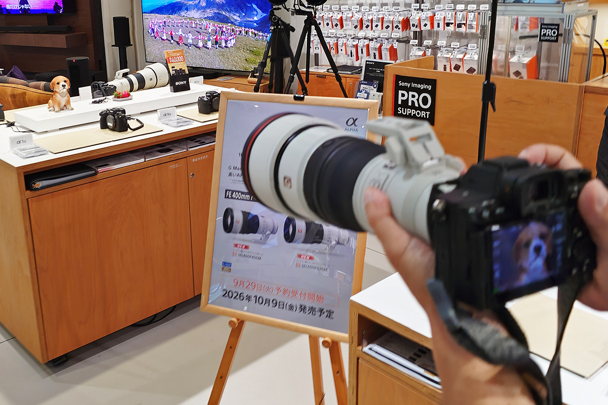 先行展示のPOPの横で、犬の置物に向けて超望遠レンズを付けたαを構えたところ