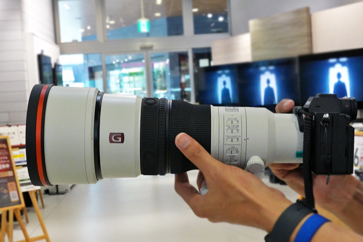 αに装着したSEL400F45GMを真横から両手で持ったところ